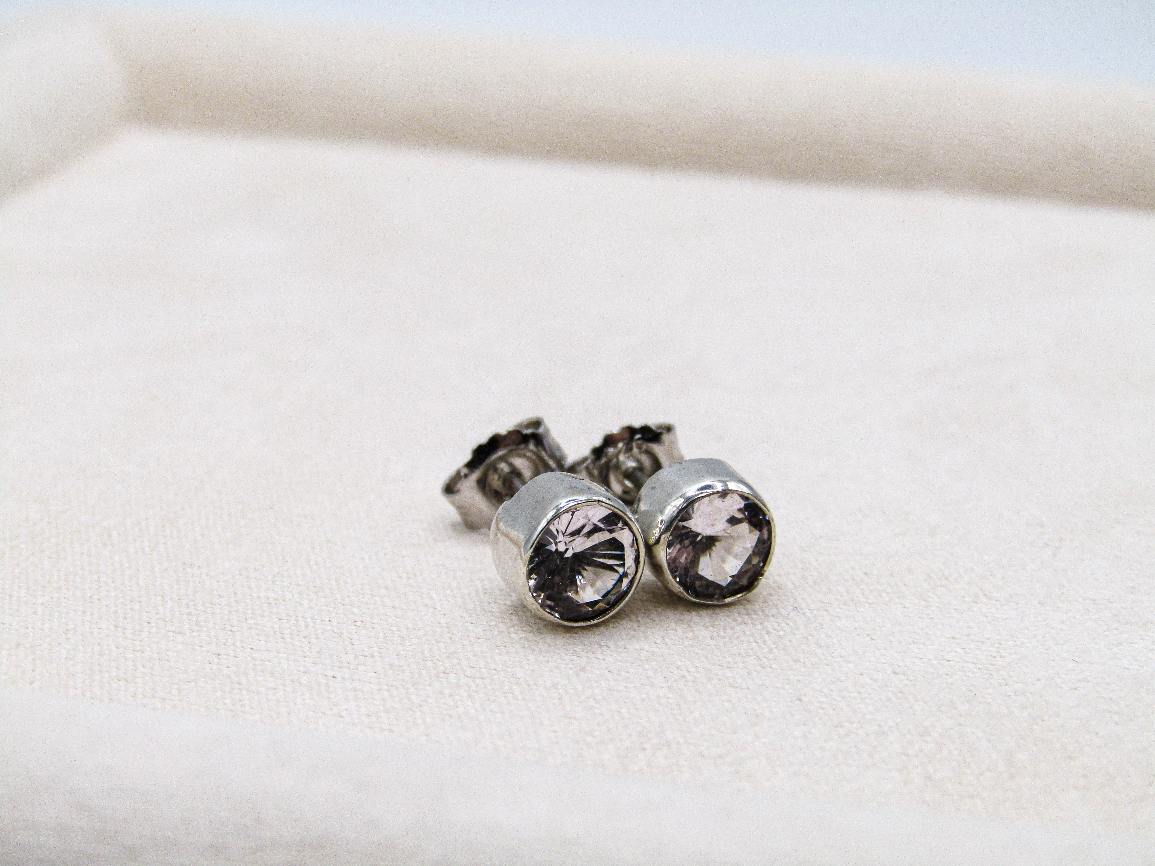 Silver stud earrings with clear gemstones on a white background