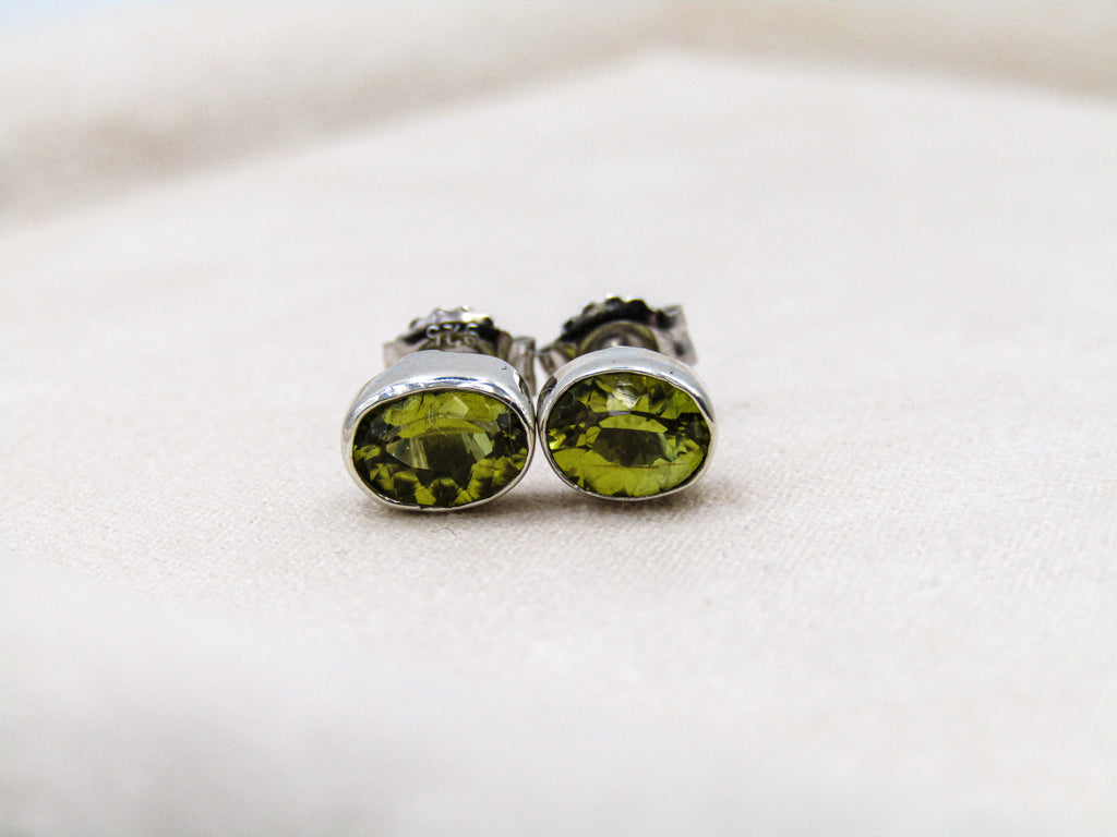 Pair of green gemstone stud earrings on a light background