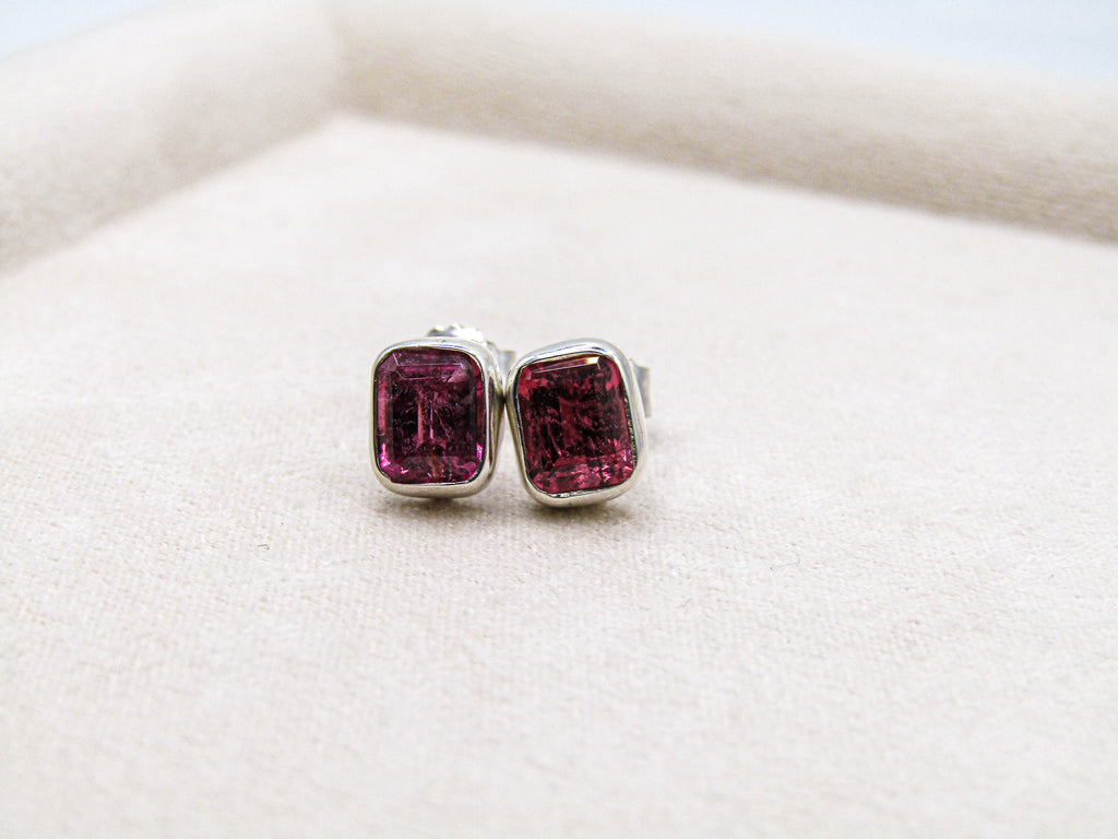Pair of earrings with pink gemstones on a white background