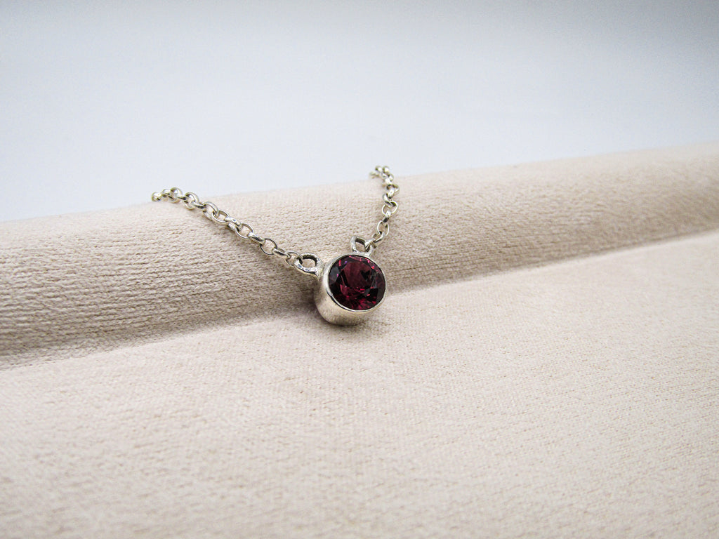 Necklace with a red gemstone on a white surface