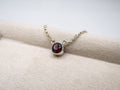 Necklace with a red gemstone pendant on a white surface