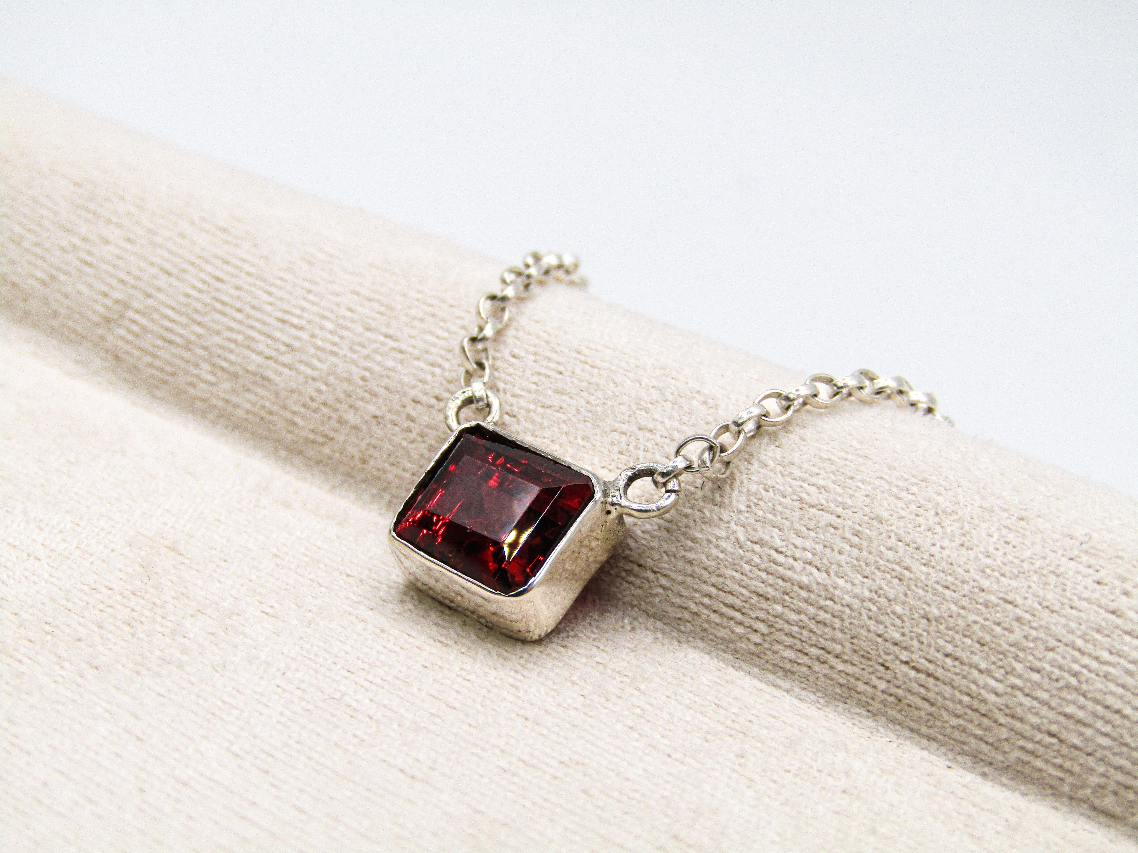 Necklace with a red gemstone pendant on a white background