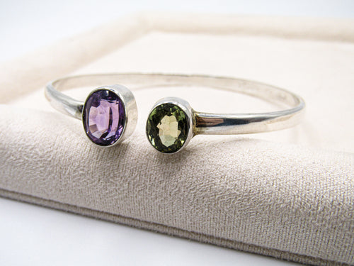 Two silver rings with gemstones on a textured surface