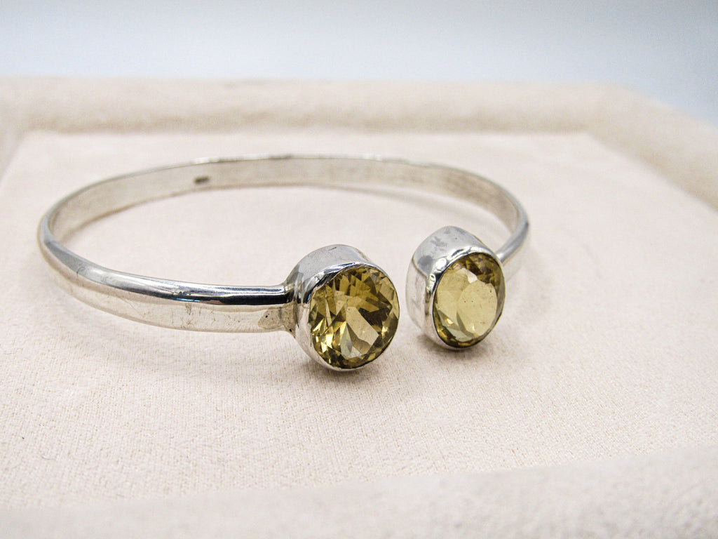 Silver bracelet with yellow gemstones on a light background