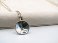Silver pendant necklace on a textured surface