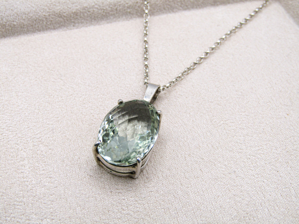 Necklace with a green gemstone pendant on a light gray background