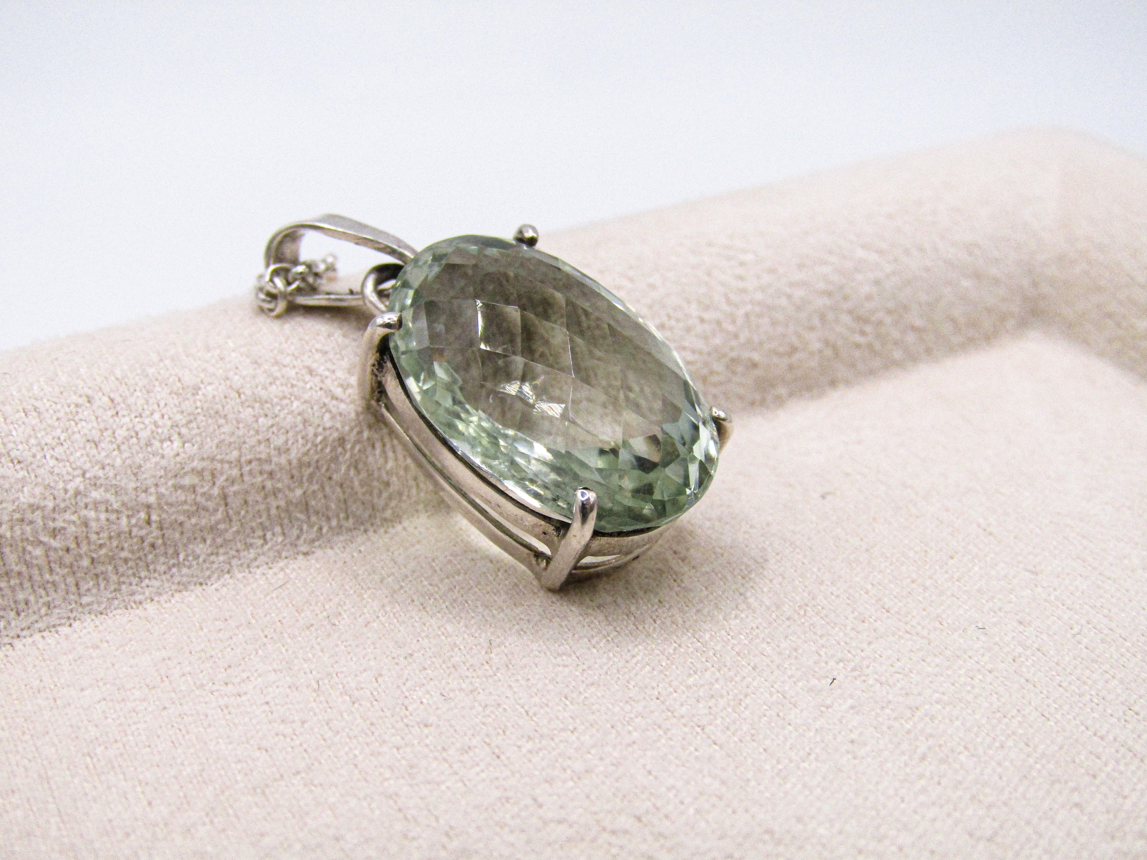 Green gemstone pendant on a white background