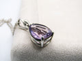 Purple teardrop pendant on a silver chain against a white background