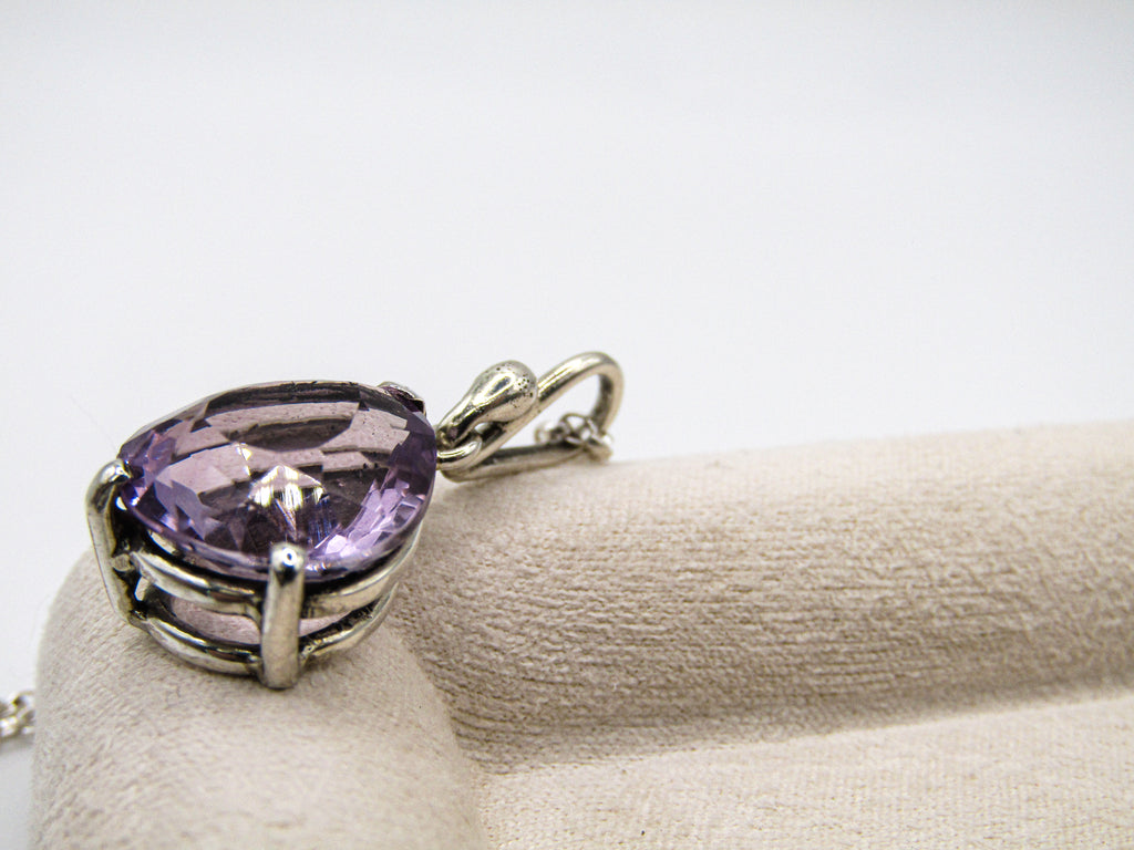 Purple heart-shaped gemstone pendant on a white background