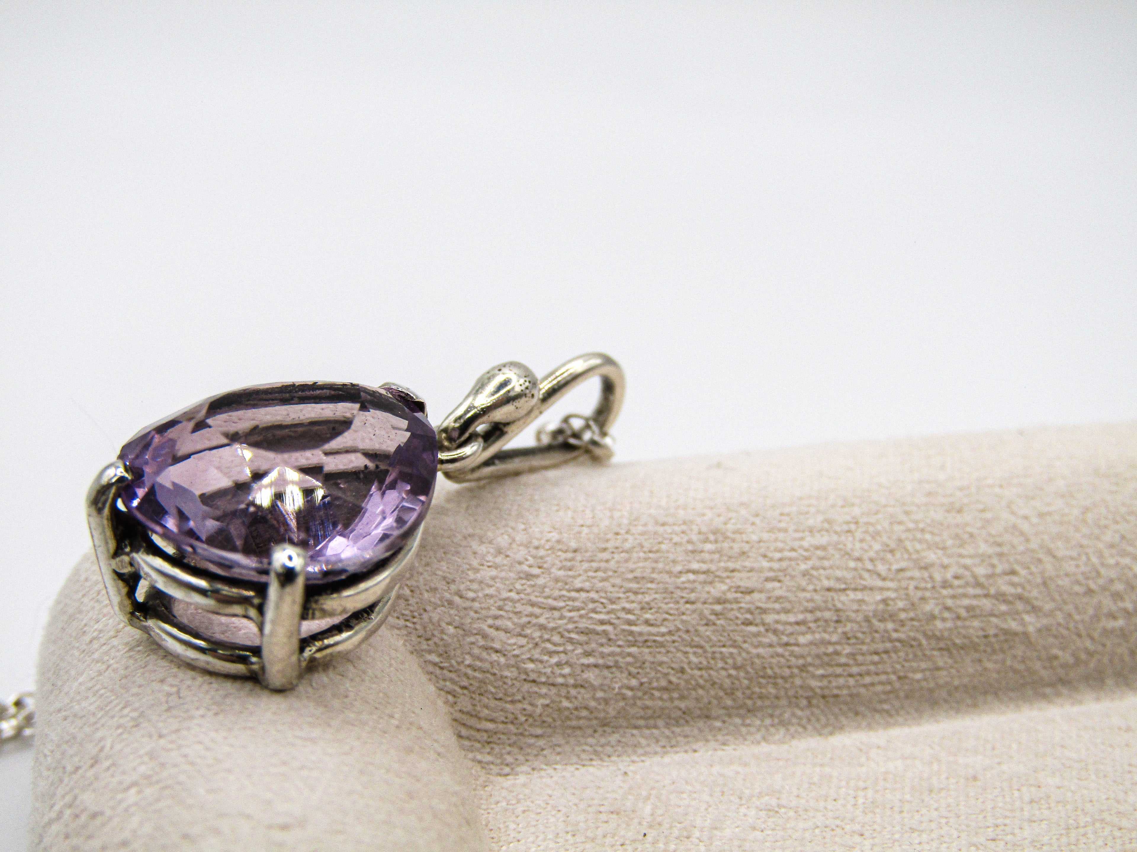 Purple heart-shaped gemstone pendant on a white background