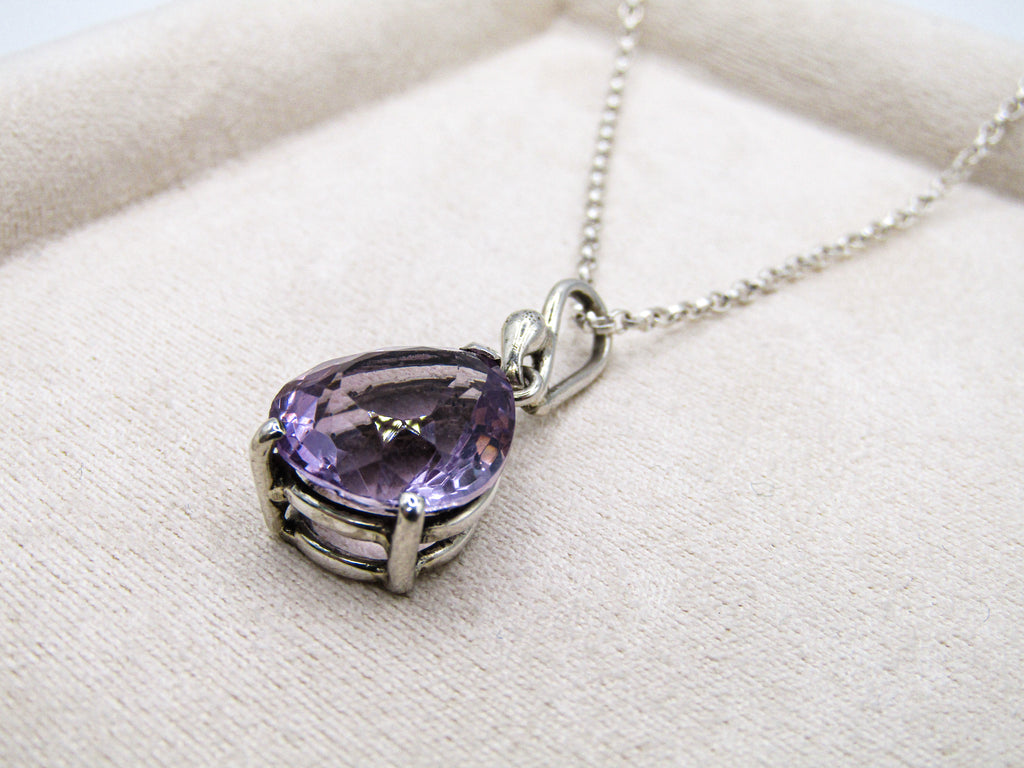 Purple gemstone necklace on a white fabric background
