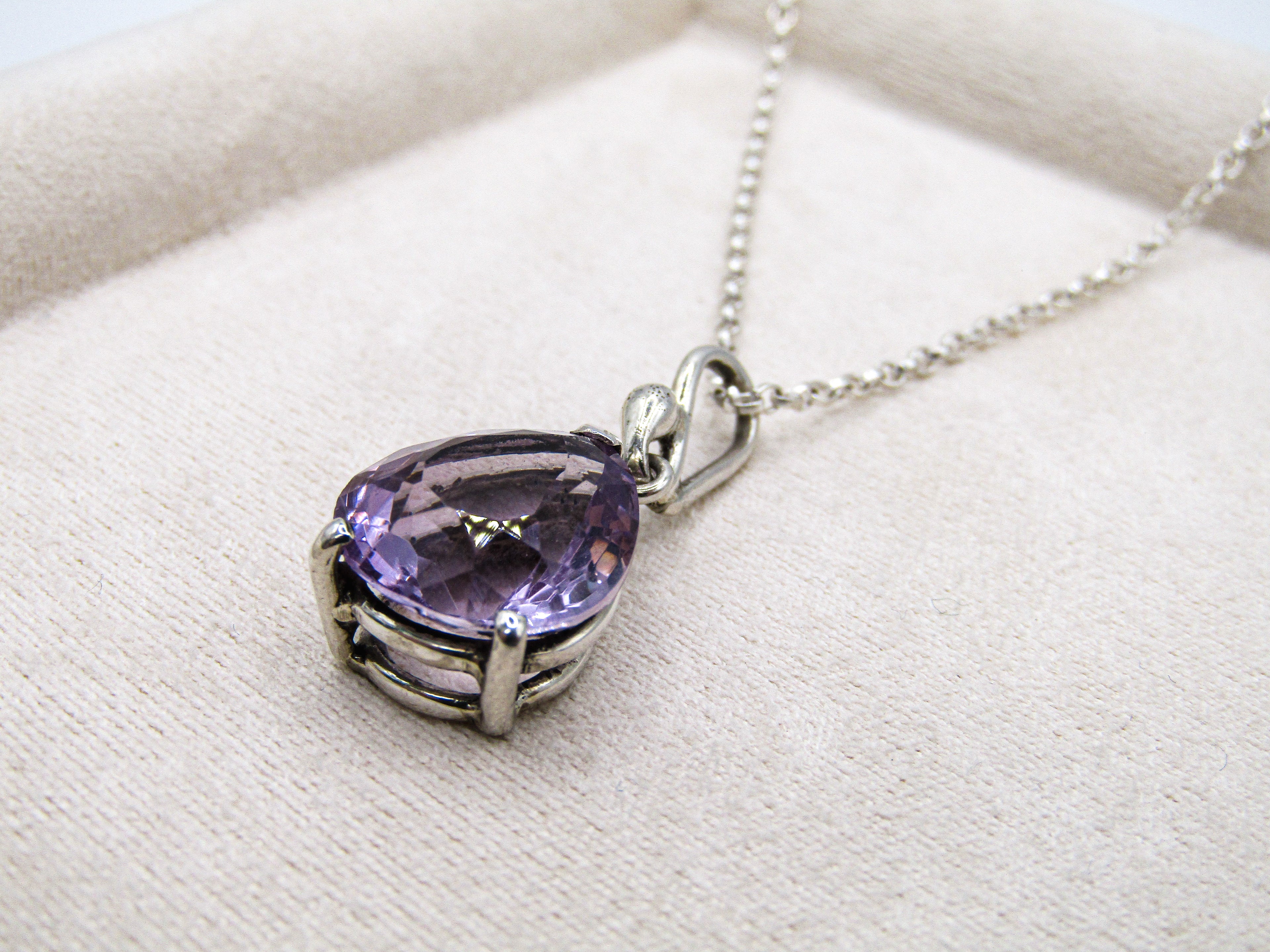 Purple gemstone necklace on a white fabric background