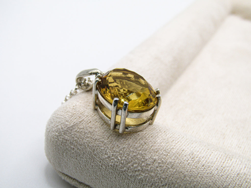 Silver ring with a yellow gemstone on a white background