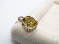 Silver ring with a yellow gemstone on a white background