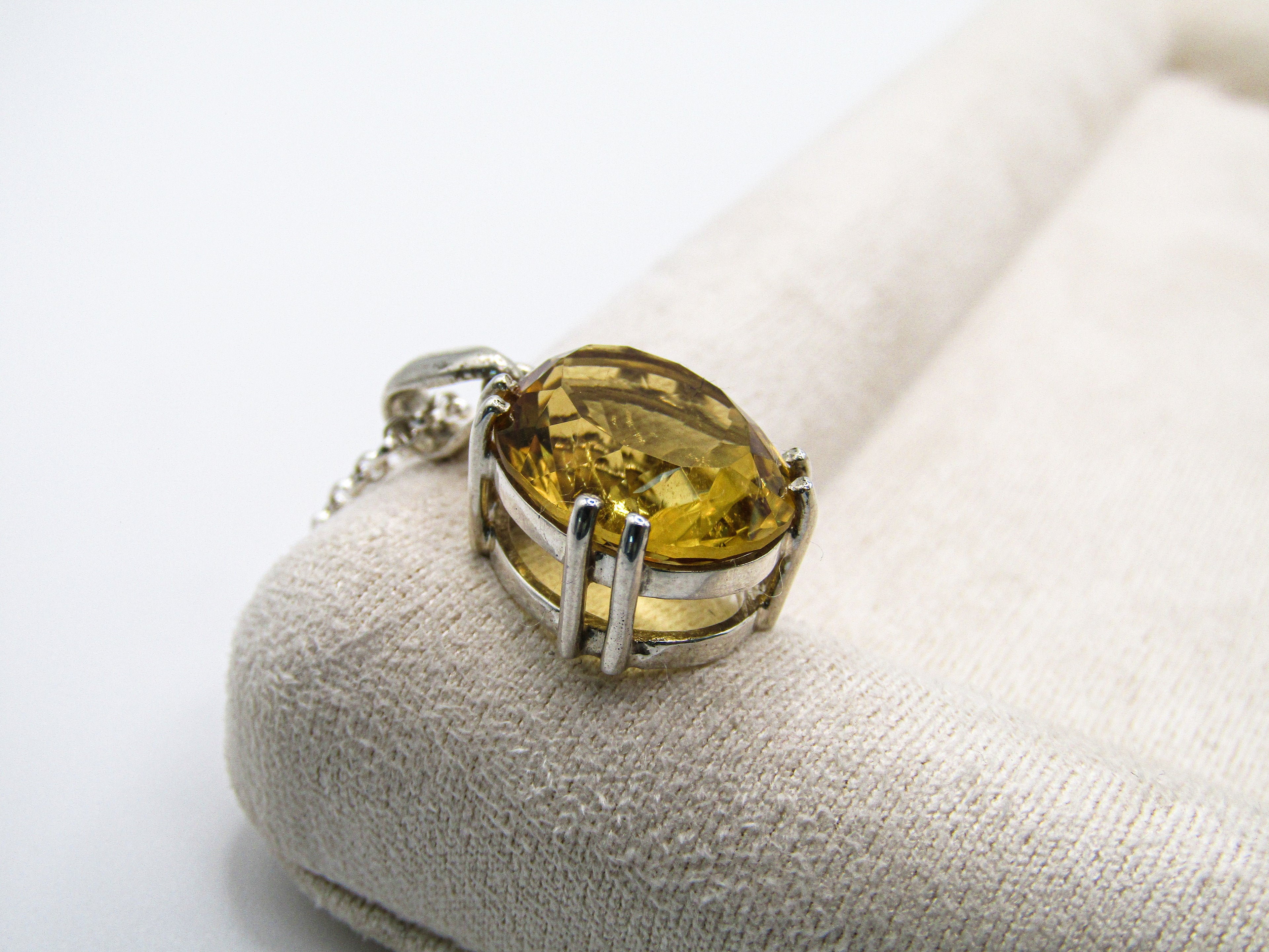 Silver ring with a yellow gemstone on a white background