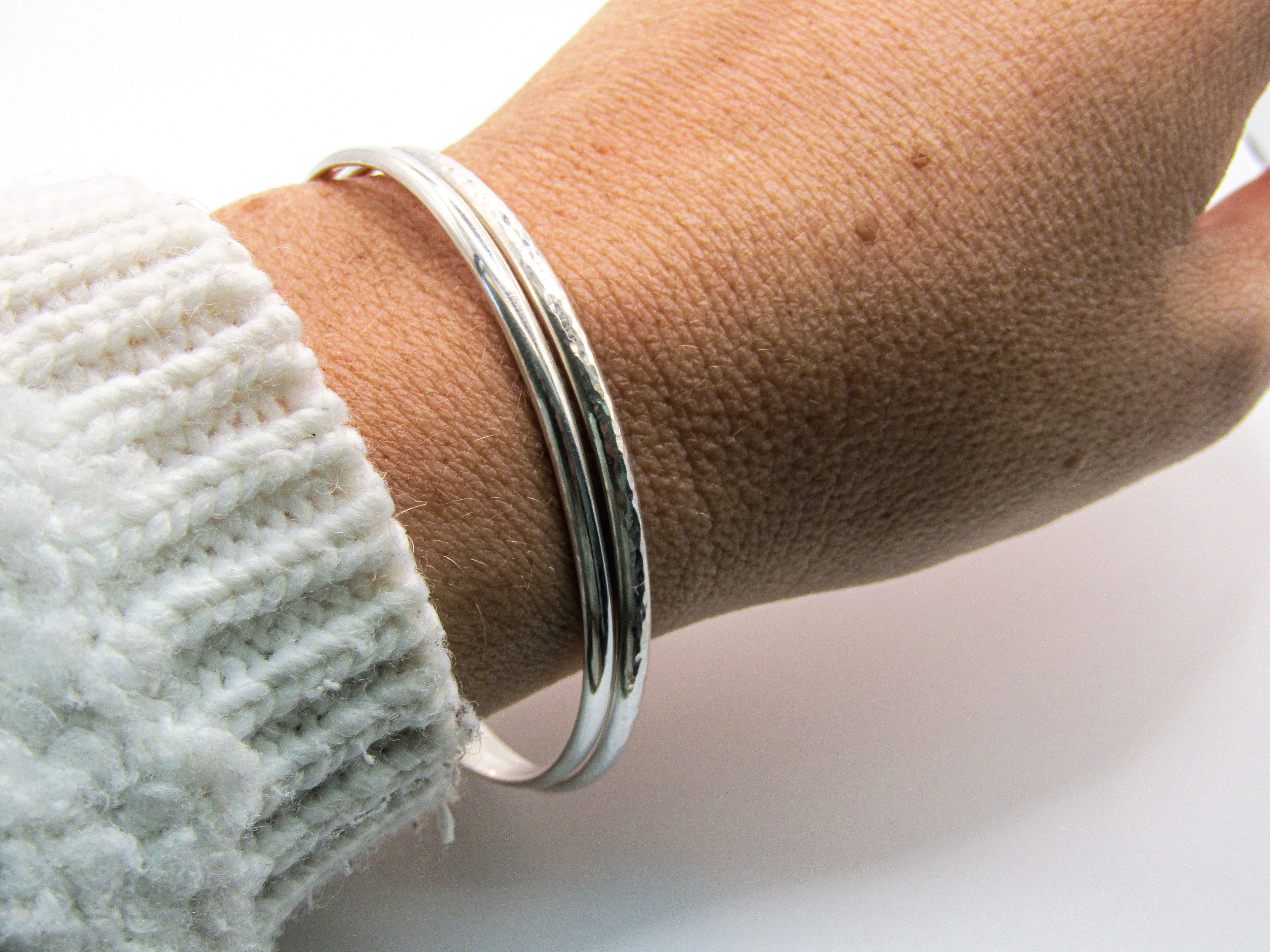Silver bracelet on a wrist with a blurred background