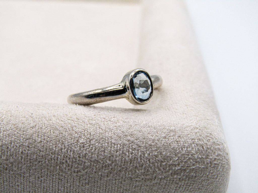 Silver ring with a gemstone on a textured surface